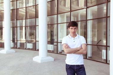 çapraz kol ve satisfa ile kameraya bakarak gündelik genç adam