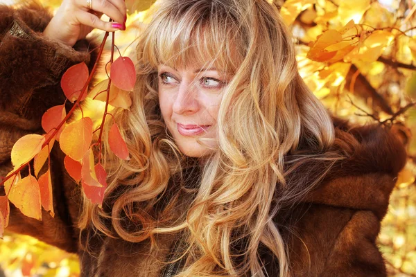 美丽金发碧眼的中年女子在秋天叶子 — 图库照片