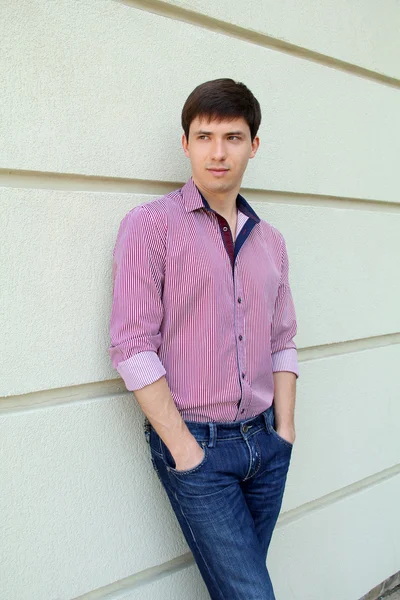 Handsome man casually leaning against the wall — Stock Photo, Image