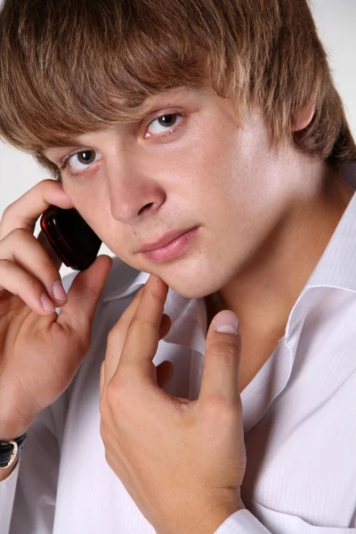 Close up of young handsome man talking on mobile phone against w — Stock Photo, Image