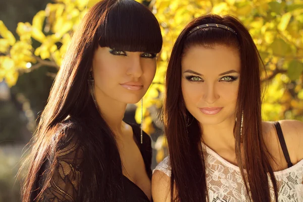 Two brunette women outdoors portrait. Soft sunny colors. — Stock Photo, Image