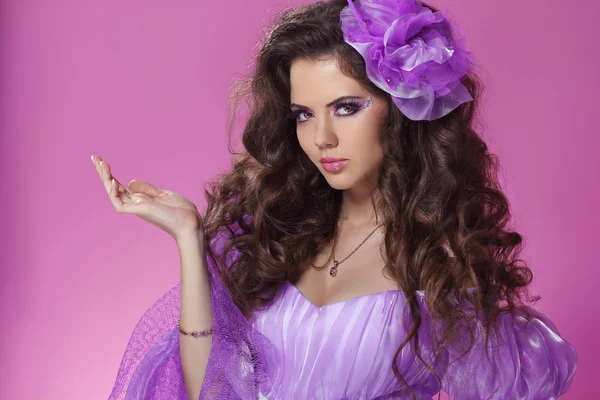 Krásná žena s dlouhými kudrnatými vlasy styl nad fialová — Stock fotografie