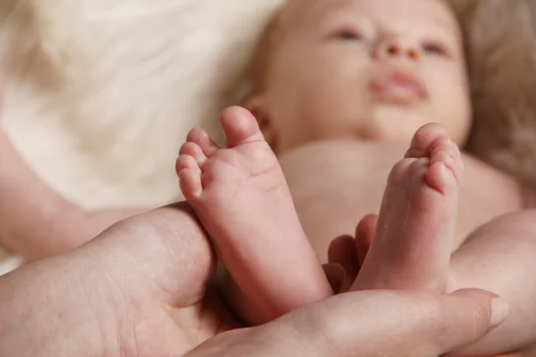 Mother hands holding foot of newborn baby — Stock Photo, Image