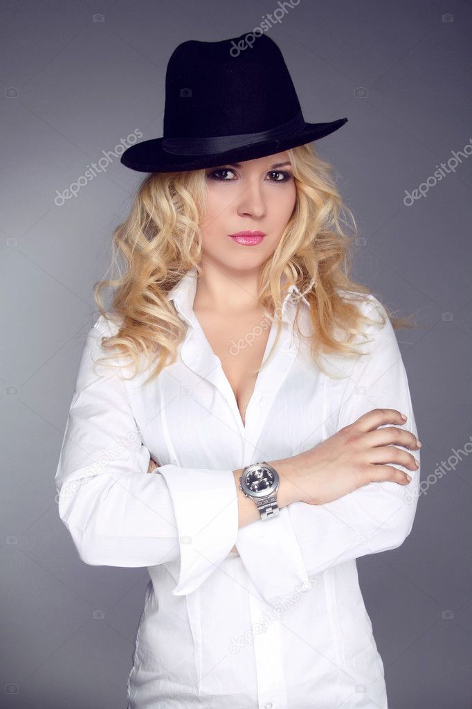 Woman wearing in white shirt and black hat isolated on grey back