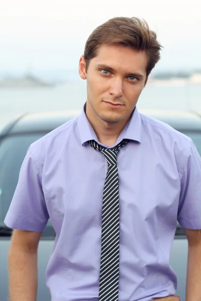 Hombre guapo apoyándose casualmente en el coche, retrato al aire libre —  Fotos de Stock