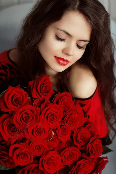 与红玫瑰有吸引力白种人微笑女人肖像博