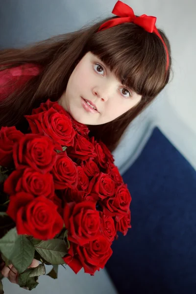 Feliz niña sonriente con flores de ramo de rosas rojas — Foto de Stock