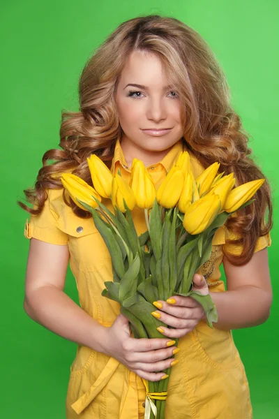 Schönes Mädchen mit Tulpenblumen auf grünem Hintergrund. Schönheit — Stockfoto