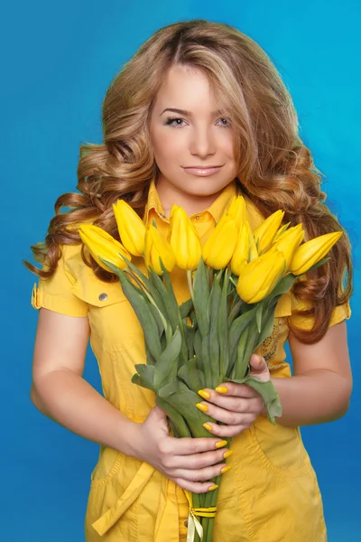Mooi meisje met tulp bloemen over blauw. schoonheid model vrouw — Stockfoto