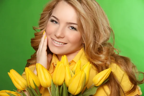 Menina sorridente feliz com tulipas amarelas floridas primavera isolado — Fotografia de Stock