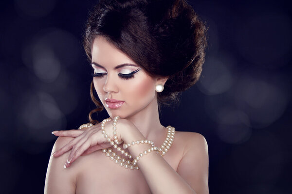 Glamour portrait of beautiful woman with pearl necklace on the b