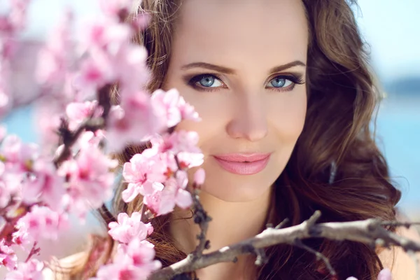 Outdoors portrait of beautiful smiling woman model in pink bloss — Stock Photo, Image