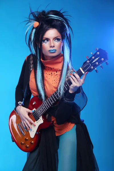 Rock girl chapeamento na guitarra elétrica isolada no fundo azul — Fotografia de Stock