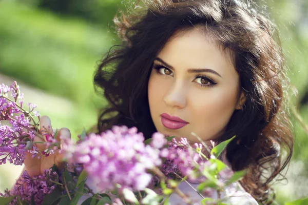 Young brunette woman with lilac flowers, Outdoors portrait — Stock Photo, Image