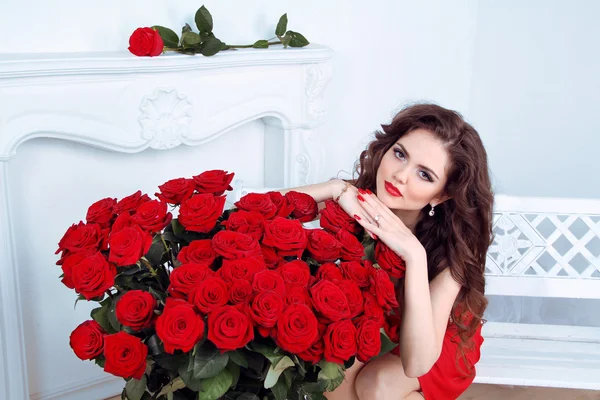 Schöne brünette Frau mit roten Rosen Blumenstrauß in moder — Stockfoto