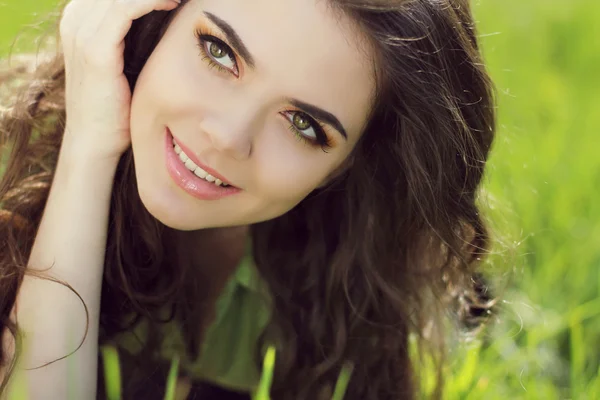 Mulher sorridente atraente descansando na grama verde, ao ar livre portra — Fotografia de Stock