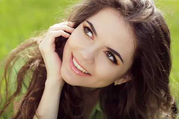 Close portrait of beautiful young woman on green grass in the su — Stock Photo, Image