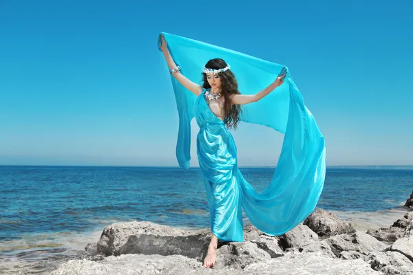 Vatten nymf. vacker kvinna i blå chiffong klänning embracing ove — Stockfoto