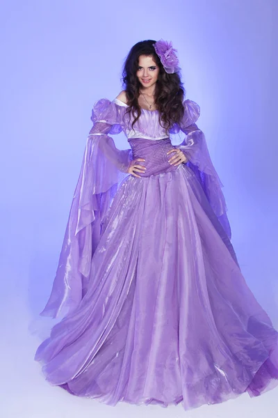 Красивая женщина модель позирует в длинном платье шифона над фиолетовым i — стоковое фото