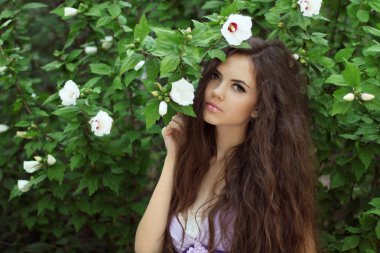 Beautiful Woman with Curly Long Hair. Outdoors Portrait on green