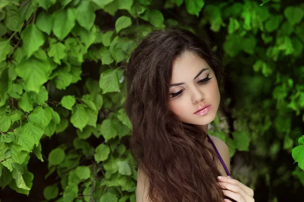 Hermosa mujer con pelo largo rizado. Al aire libre Retrato en verde — Foto de Stock