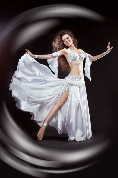 Schoonheid meisje buikdanseres in wit pak oriëntaalse dans in beweging — Stockfoto