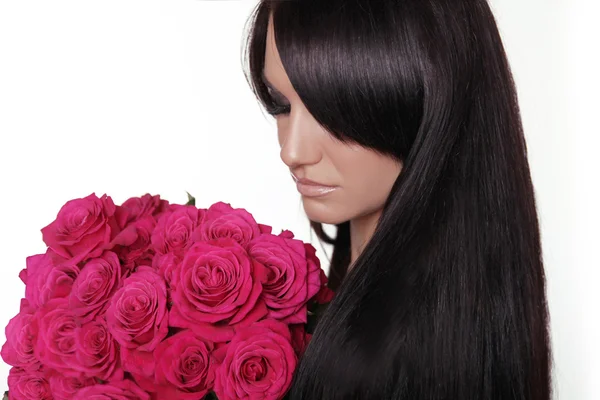 Cabelo longo e saudável. Mulher morena com franja segurando bouqu rosa — Fotografia de Stock