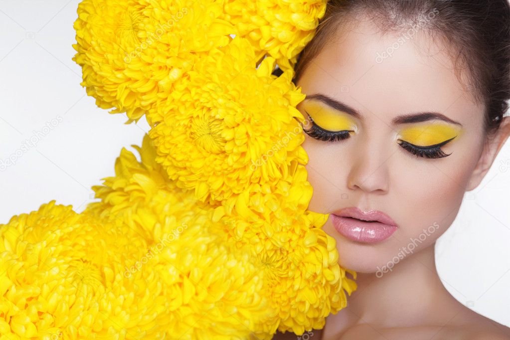 Beautiful Spa Woman over chrysanthemum flowers. Eyes makeup. Bea