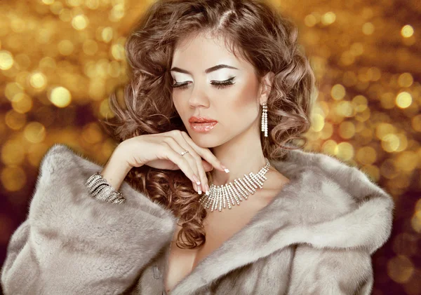 Mujer de belleza de moda de lujo en abrigo de piel sobre dorada bokeh backgr —  Fotos de Stock