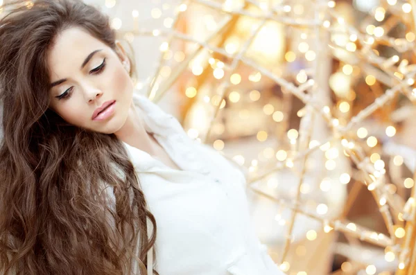 Chica morena sensual con el pelo ondulado largo sobre luces brillantes bli —  Fotos de Stock