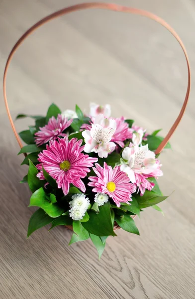 Beautiful bouquet of spring flowers in basket isolated on parque — Stock Photo, Image