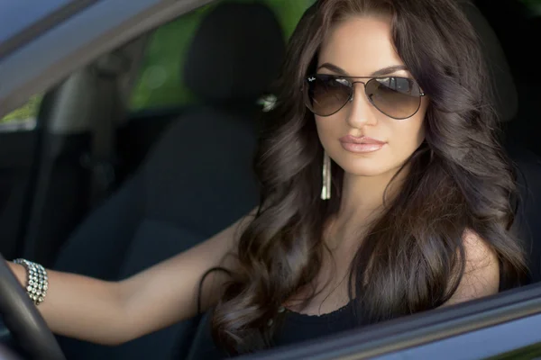Bella sexy modello di donna bruna con occhiali da sole seduto in un — Foto Stock