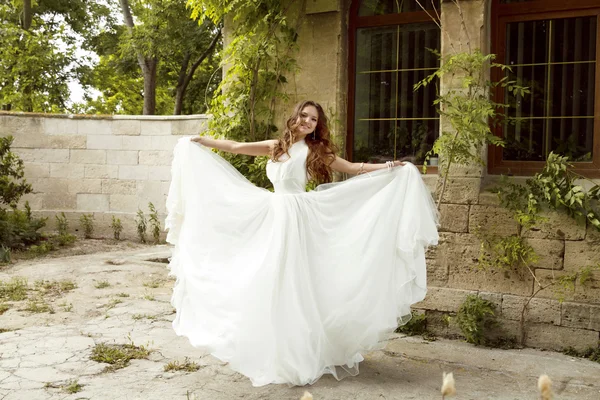 Hermosa novia mujer en lujoso vestido de novia blanco posando o —  Fotos de Stock