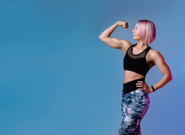 文雅的运动背景 身强体壮 肌肉强健的现代女子 蓝色健身霓虹灯横幅 健身馆 女强人穿运动服 粉色头发 交融健身动机 — 图库照片