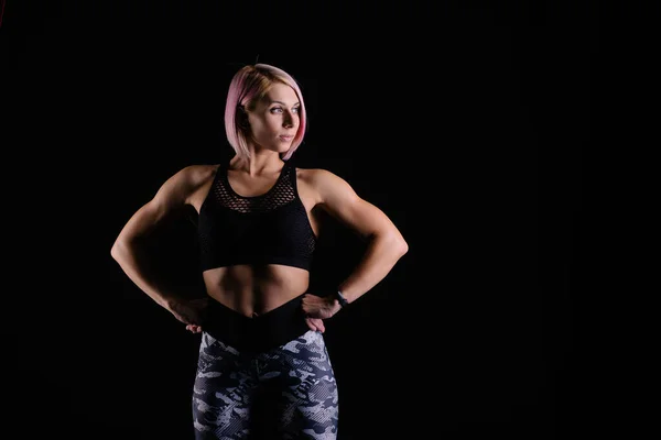 Stylish sports Black background. Sport modern woman exercising strong with muscles. fitness banner. Workout gym. Girl powerful in sportswear. Bodybuilding. Pink hair. crossfit fitness motivation