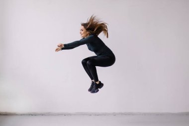 Arka planda spor kıyafetli güzel bir kadının uzun bir portresi var.