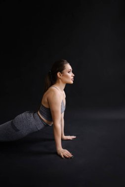 Siyah arka planda sağlıklı bir vücudu olan güzel bir genç kadının portresi.