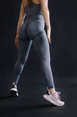 Siyah arka plan üzerinde egzersiz yapan genç ve güzel bir kadın.