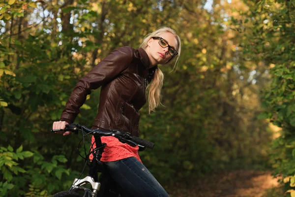 Flicka på cykel i skogen — Stockfoto