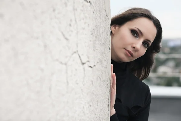 Brunette meisje in de buurt van muur — Stockfoto