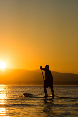 Man paddling stand up paddle board