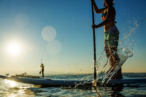 Mujeres remando stand up paddle board Imagen De Stock