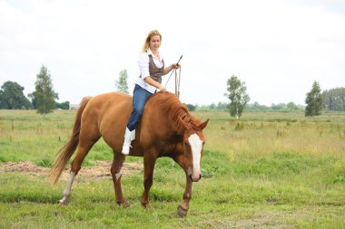 Beautiful blonde woman riding horse bareback clipart