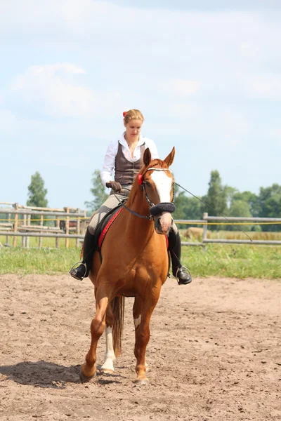 Hermosa joven rubia montando caballo castaño — Foto de Stock