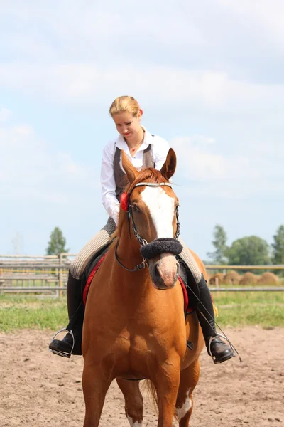 Beautiful young blonde woman riding chestnut horse — Stock Photo, Image