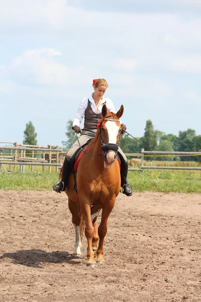 Hermosa joven rubia montando caballo castaño — Foto de Stock