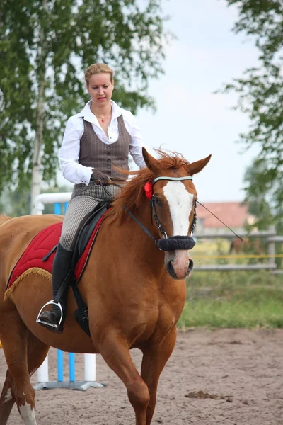 Szép fiatal szőke nő gesztenye ló lovaglás — Stock Fotó