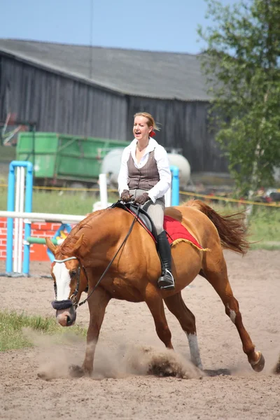 Beautiful young blonde woman riding chestnut horse — Stock Photo, Image