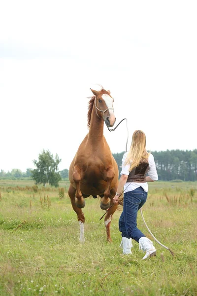 Young blonde woman commanding horse to rear — Stock Photo, Image