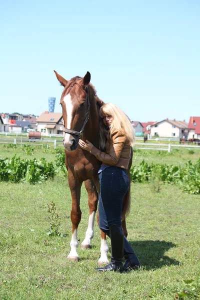 Blond kobieta i kasztanów horse — Zdjęcie stockowe